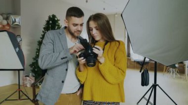 Profesyonel fotoğrafçı adam güzel model kız fotoğraf Studio kapalı için dijital kamerada Fotoğraflar gösteriyor