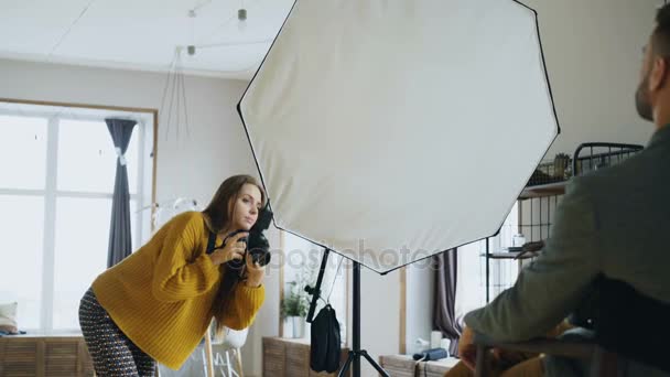 Profesyonel fotoğrafçı kadın alarak fotoğraf Studio dijital fotoğraf makinesi ile işadamı model kızın — Stok video