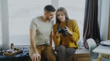 Tatilden sonra evde dijital kamera üzerinde seyahat fotoğrafları izlerken mutlu gülümseyen Çift