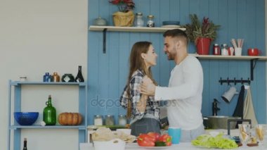 Slowmotion neşeli genç çiftin evde mutfakta yemek yaparken dans eğlenceli