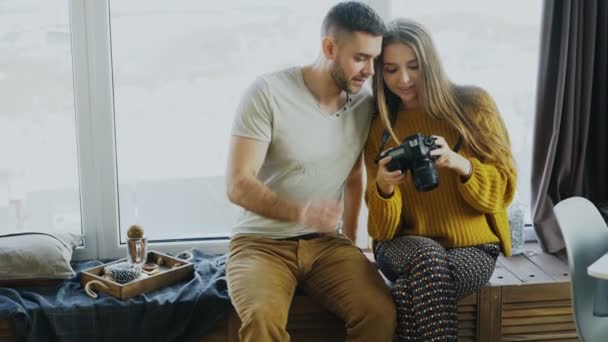 Happy smiling couple watching photos from travel on digital camera at home after vacation — Stock Video