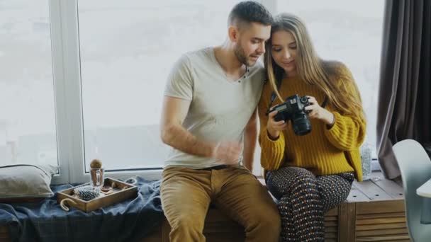 Feliz casal sorridente assistindo fotos de viagens na câmera digital em casa após as férias — Vídeo de Stock