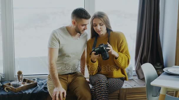 Ευτυχισμένο ζευγάρι χαμογελά βλέποντας φωτογραφίες από το ταξίδι στην ψηφιακή φωτογραφική μηχανή στο σπίτι μετά τις διακοπές — Αρχείο Βίντεο