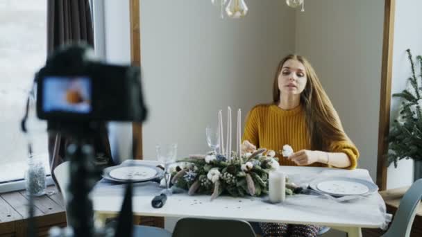 カメラのフードの装飾デザインについてのビデオのブログを記録するテーブルに座って魅力的な陽気な女性 — ストック動画