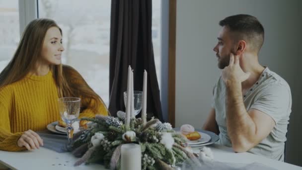 Молода пара їсть десерт після обіду і розмовляє в кафе в приміщенні — стокове відео