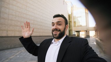 Genç işadamı smartphone online görüntülü sohbet iş toplantı açık havada mı konuşuyor sakallı