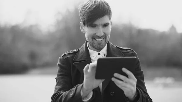 Fiatal mosolygó üzletember tabletta számítógép segítségével szünetben az utcán — Stock Fotó