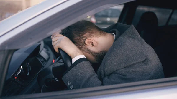 Jovem barbudo homem de negócios sentado no carro muito chateado e estressado após falha dura e se movendo em engarrafamento — Fotografia de Stock