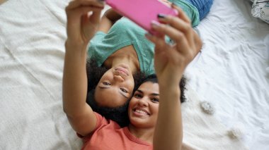Güzel karışık yarış komik kız yatak odası evde yatakta selfie portre yapma Üstten Görünüm