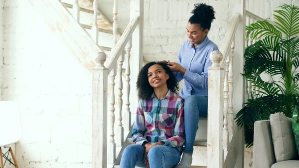 Zwei afrikanische amerikanische lockige Mädchen sistres machen Spaß lockige Frisur einander und haben Spaß zu Hause — Stockfoto