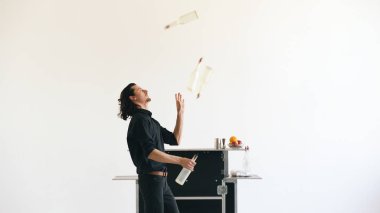 Şişe hokkabazlık ve beyaz arka plan üzerinde mobil bar masasında kokteyl sallayarak iş barmen adam