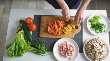Üstten Görünüm kadının bir ahşap tahta kesme sebze pizza yemek için evde mutfakta eller