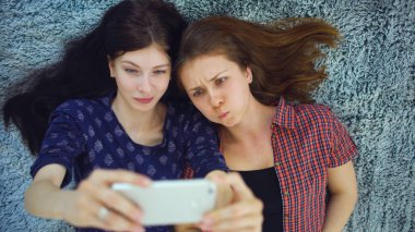 İki güzel kız yatakta evde yatak odasında selfie portre yapmak pijama Üstten Görünüm