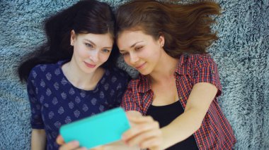 İki güzel kız yatakta evde yatak odasında selfie portre yapmak pijama Üstten Görünüm