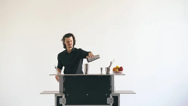 Professeur barman secouant cocktail à la table de bar mobile sur fond blanc — Photo