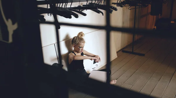 Joven bailarina adolescente llorando y llorando libro se sienta en el suelo en el pasillo en el interior —  Fotos de Stock