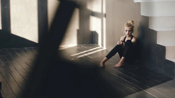 Крупный план молодой танцовщицы-подростка, плачущей после потери перфоманса, сидит на полу в зале — стоковое фото