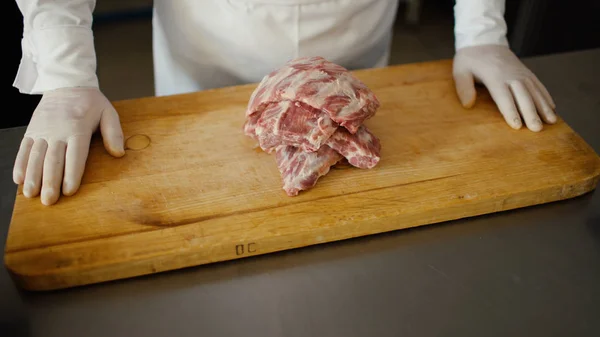 Closeup of professional chef prepare meat ribs on cutting board at restaurant kitchen — Stock Photo, Image