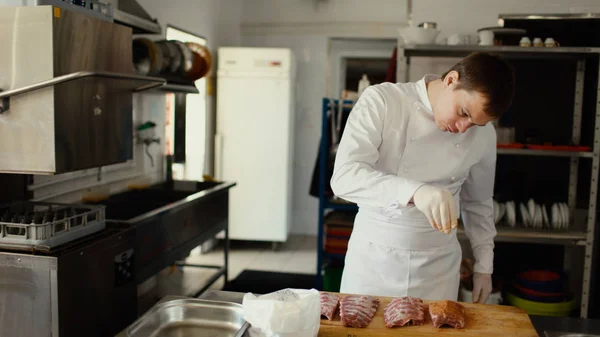 Chef professionnel homme préparer des côtes de viande avec des épices sur la planche à découper au restaurant cuisine — Photo