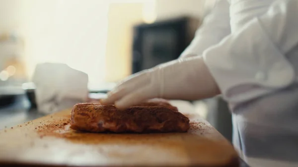 Primer plano del chef profesional hombre preparar costillas de carne con especias en la tabla de cortar en la cocina del restaurante — Foto de Stock