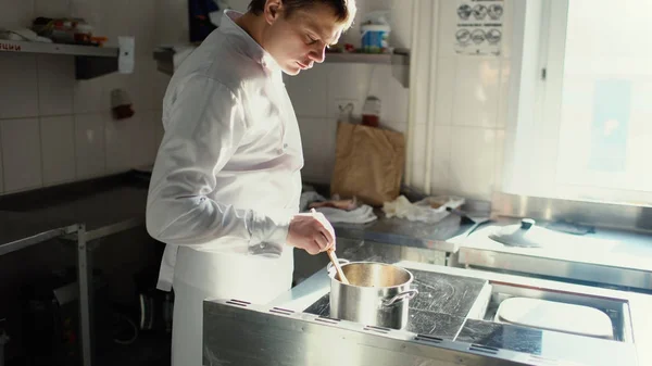 Hombre chef profesional preparar salsa con especias en el horno en la cocina del restaurante — Foto de Stock