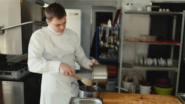 Chef professionnel homme préparer sauce sauce sauce avec des épices au restaurant cuisine — Photo