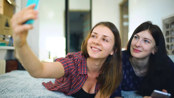 Šťastné veselé sestry takže selfie v ráno a bavit se na posteli v ložnici doma — Stock fotografie