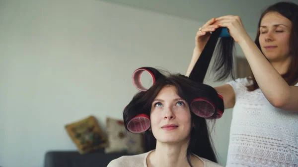 友人を作る 2 つの幸せな女性お互いカーラー髪型を楽しいし、家で楽しい時を過す — ストック写真