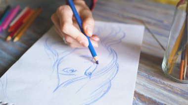 El boyama closeup üstünde kağıt defter ile kalemler sketch. İşyerinde kadın sanatçı