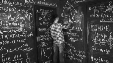 Genç bilim adamı adam yazmak takoz kimya ve Matematiksel denklemler duvar oda iç
