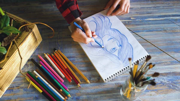 Gros plan de croquis de peinture à la main féminine sur carnet de papier avec crayons. Femme artiste au travail — Photo