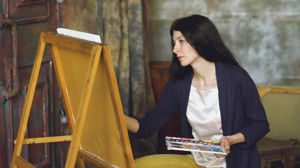 Jeune femme artiste dessiner pictrure avec aquarelle peintures et pinceau sur toile de chevalet — Photo