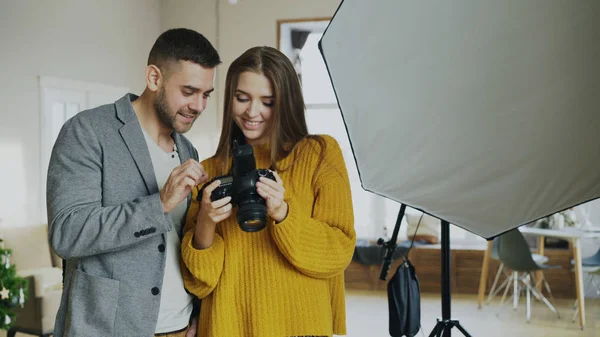 プロのカメラマンの男写真スタジオ室内で美しいモデルの女の子にデジタル カメラの写真を表示 — ストック写真