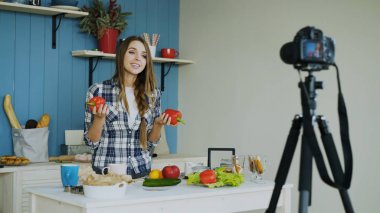 Neşeli çekici kadın evde mutfak vejetaryen sağlıklı gıda dslr fotoğraf makinesi ile ilgili video blog kayıt