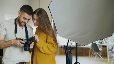 Profesyonel fotoğrafçı adam güzel model kız fotoğraf Studio kapalı için dijital kamerada Fotoğraflar gösteriyor