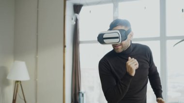 Sanal gerçeklik kulaklık dans ve oyun 360 video oyunu ile evde genç adam heyecanlı