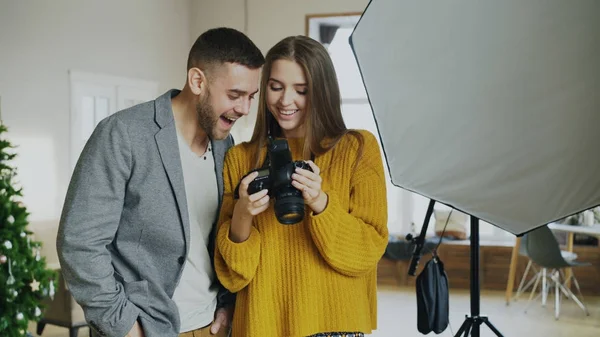 Profi fotós nő bemutató képek a digitális fényképezőgép vonzó modell férfi photo studio beltéri — Stock Fotó