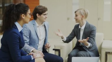 Modern ofis Merkezi kanepede oturan iş ortakları ile iş kadını söz ve duscussing gelecek sözleşme