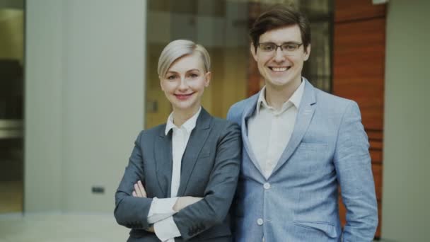 Retrato del exitoso hombre de negocios y mujer de negocios sonriendo y mirando a la cámara en la oficina moderna — Vídeos de Stock