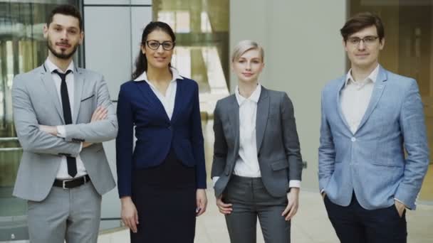 Портрет группы деловых людей, улыбающихся в современном офисе. Команда бизнесменов и деловых женщин, стоящих вместе — стоковое видео