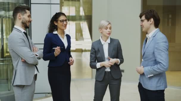 Retrato del grupo de gente de negocios hablando y luego sonriendo mirando a la cámara en el moderno salón de oficinas en el interior — Vídeos de Stock