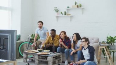 Evde spor oyun TV izlerken mutlu arkadaş grubu. Onlar atlama ve onların favori takım bağırmaya rekabet kazanmak