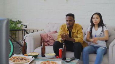 Televizyonda spor maç birlikte evde izliyor ve onların favori takım bağırmayı çok etnik gruptan oluşan çift evde kazanmak