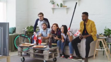 Çok etnik grup arkadaşıyla hokey Şampiyonası birlikte evde onların favori takım tezahürat TV izlerken Kanada ulusal bayrakları ile sporseverler