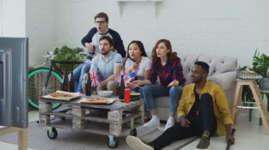 Çok etnik grup arkadaşıyla hokey Şampiyonası birlikte evde onların favori takım tezahürat TV izlerken İngiliz ulusal bayrakları ile sporseverler