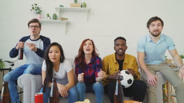 Glada unga vänner titta på sport på Tv och firar favoritlag seger hemma — Stockvideo