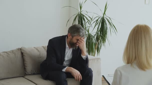 Hombre de negocios deprimido hablando de sus porblems con la psicóloga femenina — Vídeo de stock