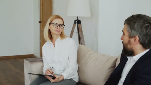 Mulher experiente psiquiatra ouvindo paciente empresário deprimido em seu escritório — Vídeo de Stock