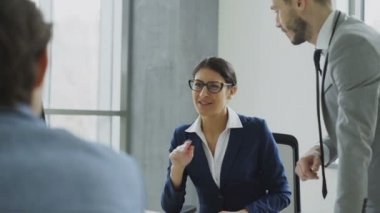 Modern ofis masada oturan kadın ve erkek arkadaşları ile konuşurken işkadını