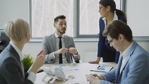 Biznesmen omawiania projektu przyszłej działalności z kolegów płci męskiej i żeńskiej, siedzi przy stole w nowoczesnym biurze — Wideo stockowe